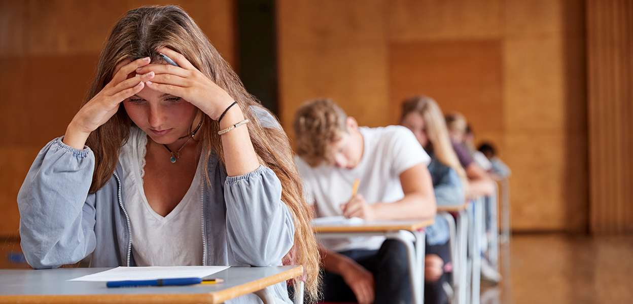 Student sitting alone in school hallway