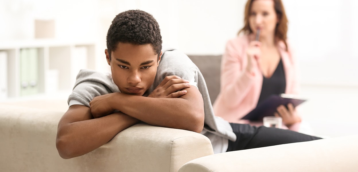 Teen sitting alone looking distressed